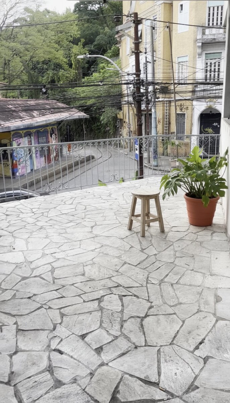 Same balcony with a simple stool and potted plant added