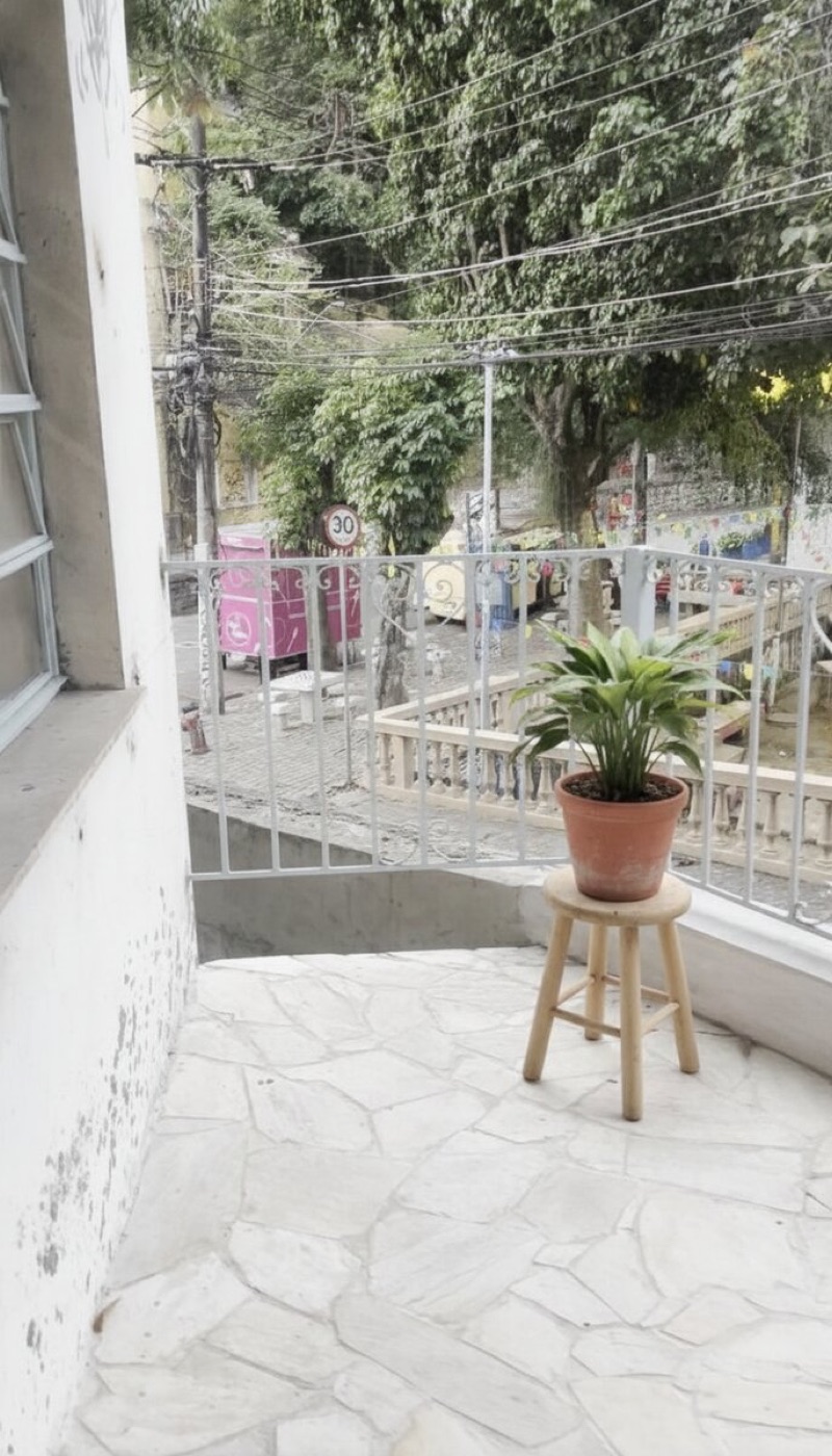 Same balcony with a simple stool and potted plant added