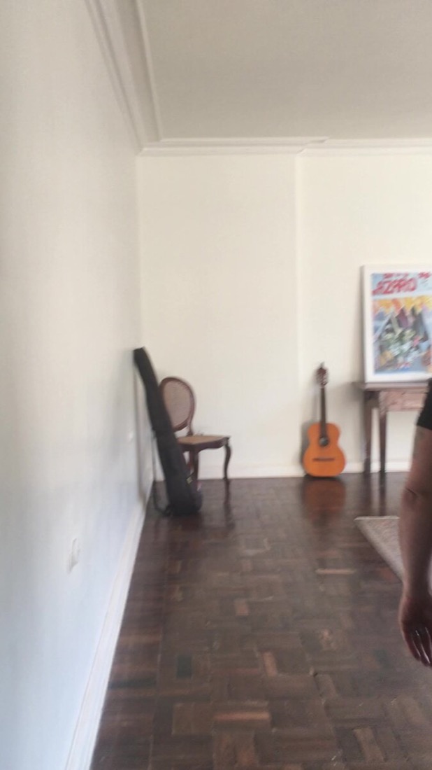 Original cane chair, guitar and framed art left in an empty room