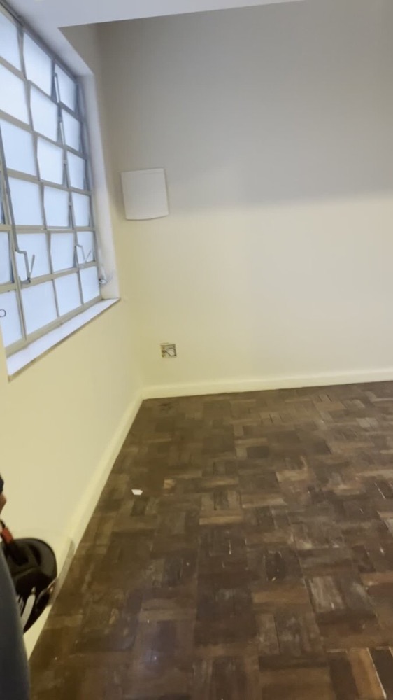 Wider view of the same bare bedroom and parquet floor