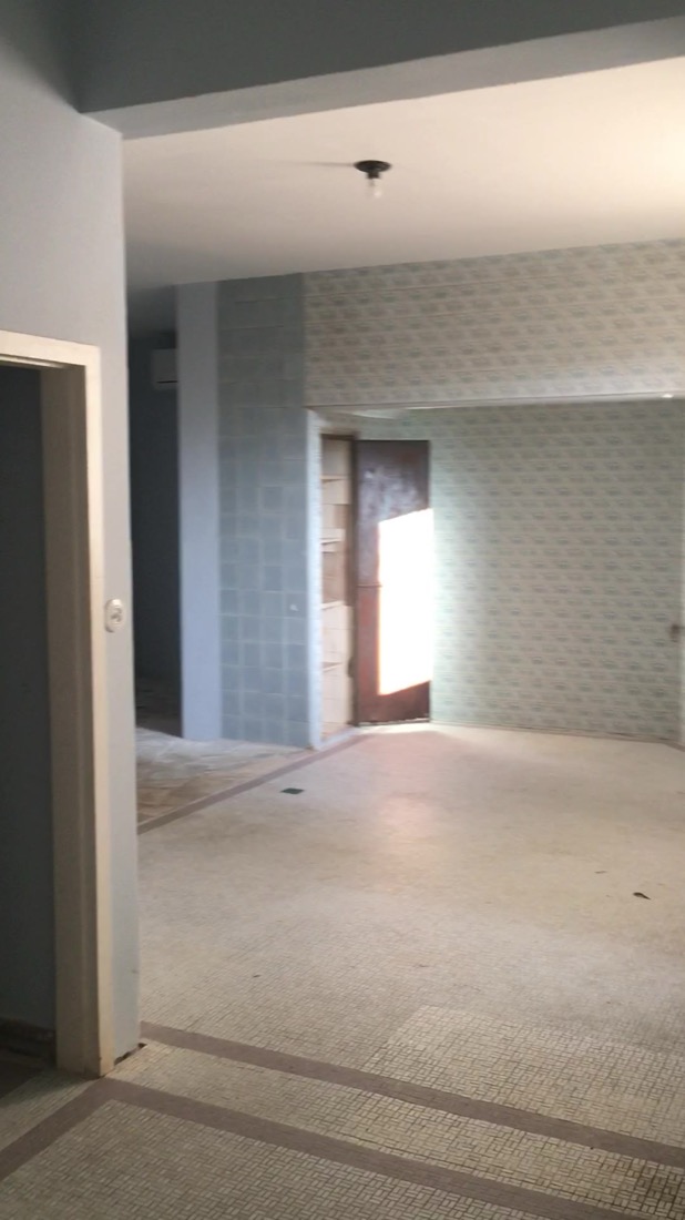 Room with original patterned floor tile and a decorative tiled column
