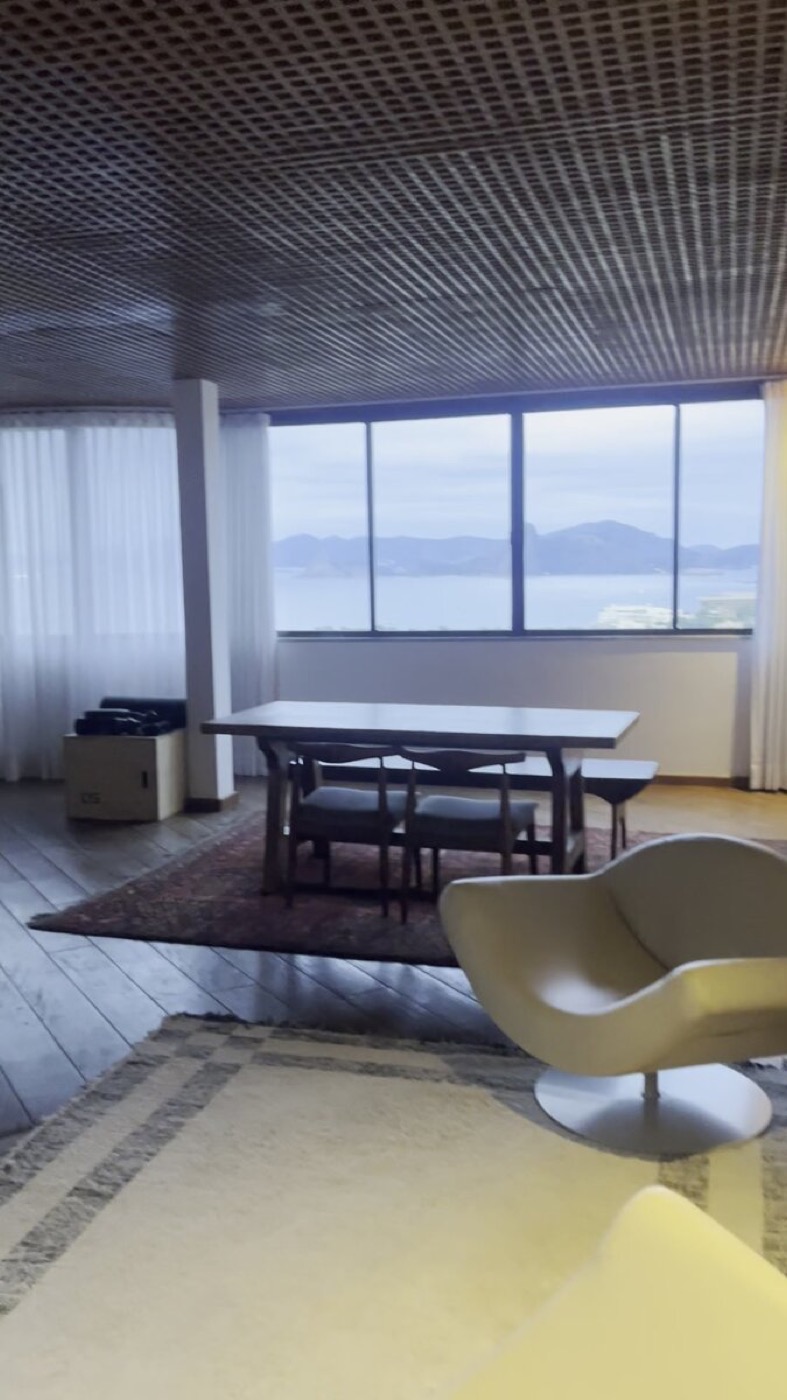 Penthouse living area with dining table and bay view