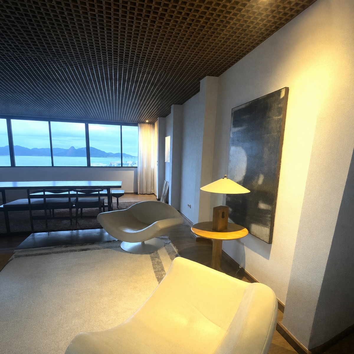 Living and dining area with sculptural chairs and bay view