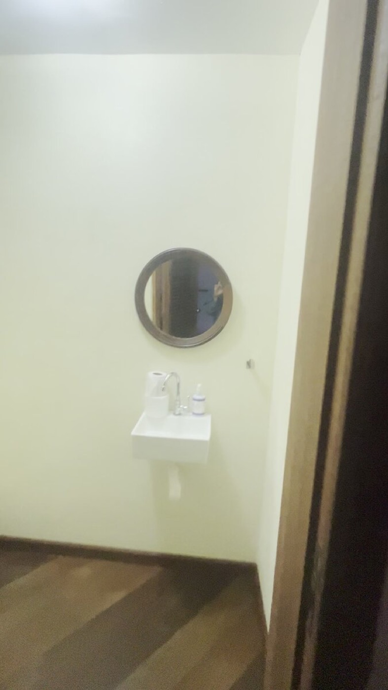 Minimalist round mirror and floating sink in a penthouse powder room