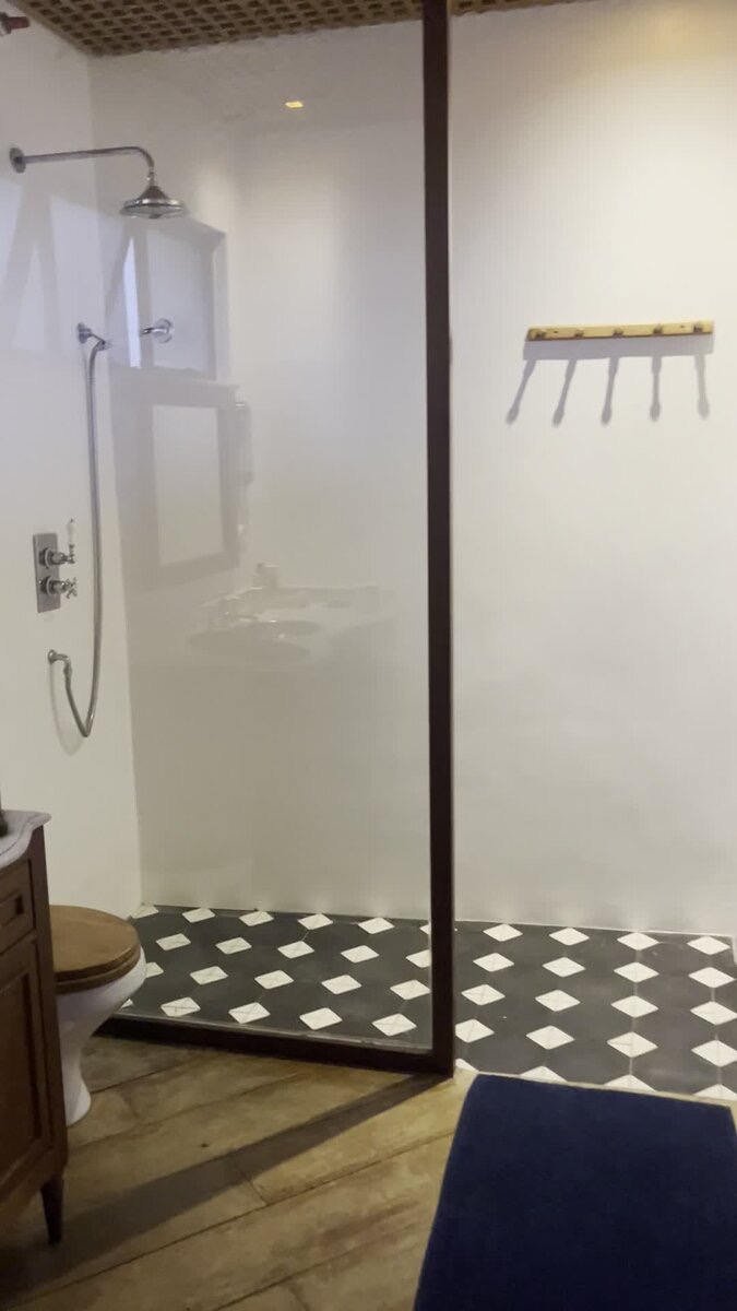 Second bathroom with glass shower stall and patterned tile floor