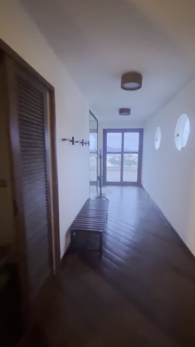 Upper-floor hallway with round porthole windows leading to the terrace
