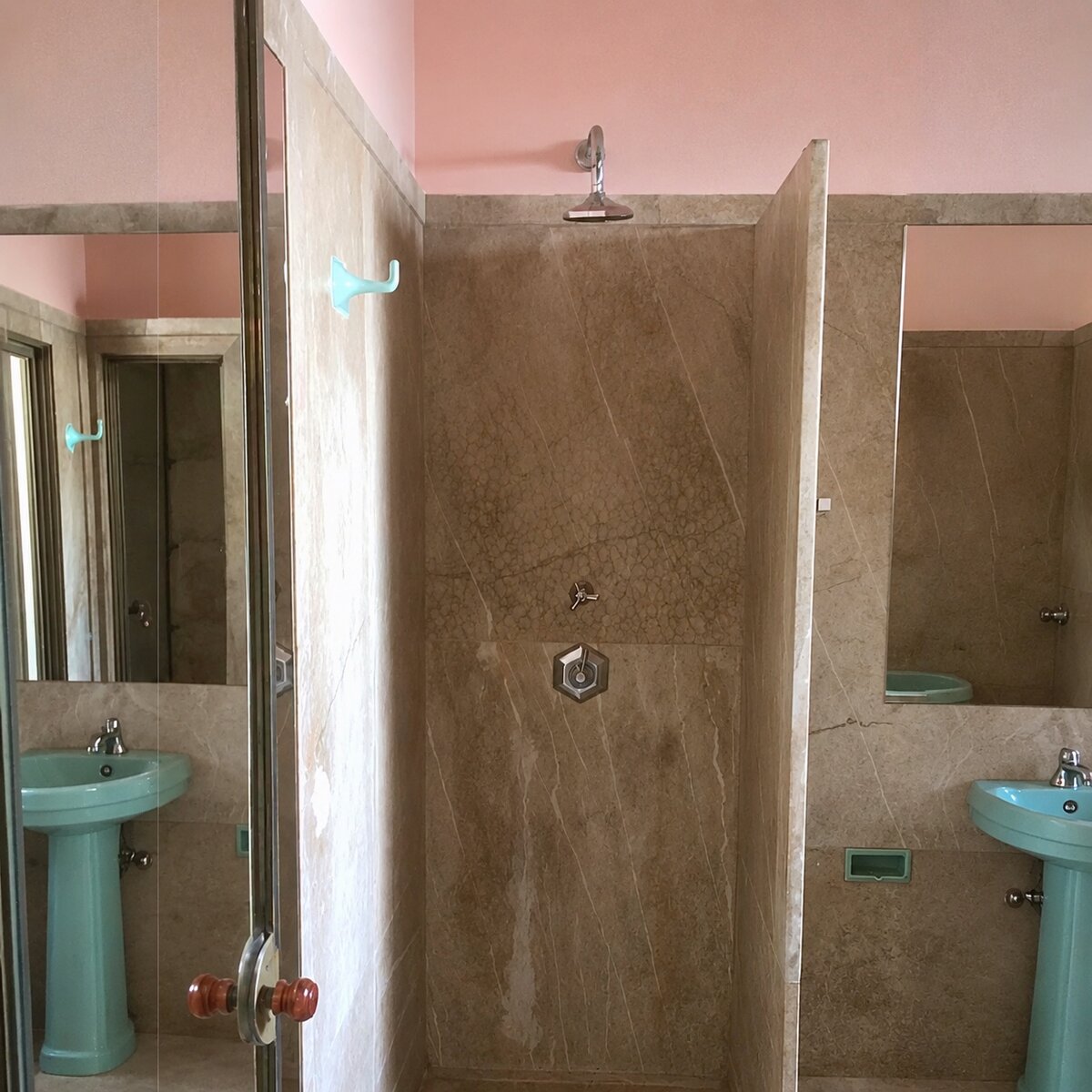 Finished bathroom with marble walls and turquoise fixtures