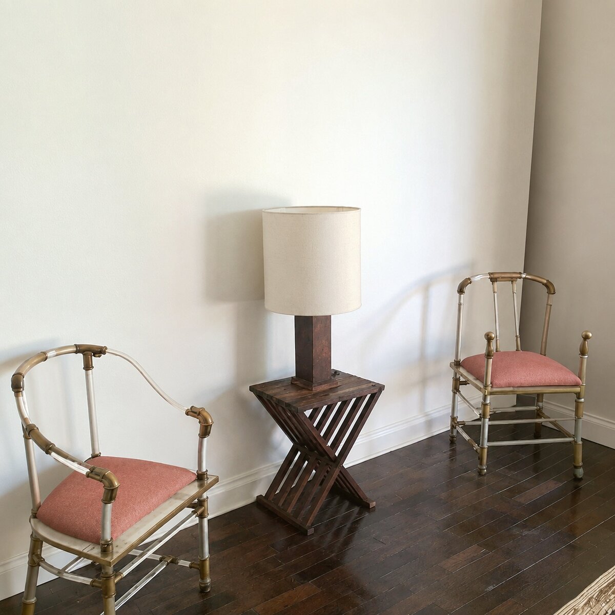 Pair of bamboo-style armchairs flanking an X-frame side table with a lamp