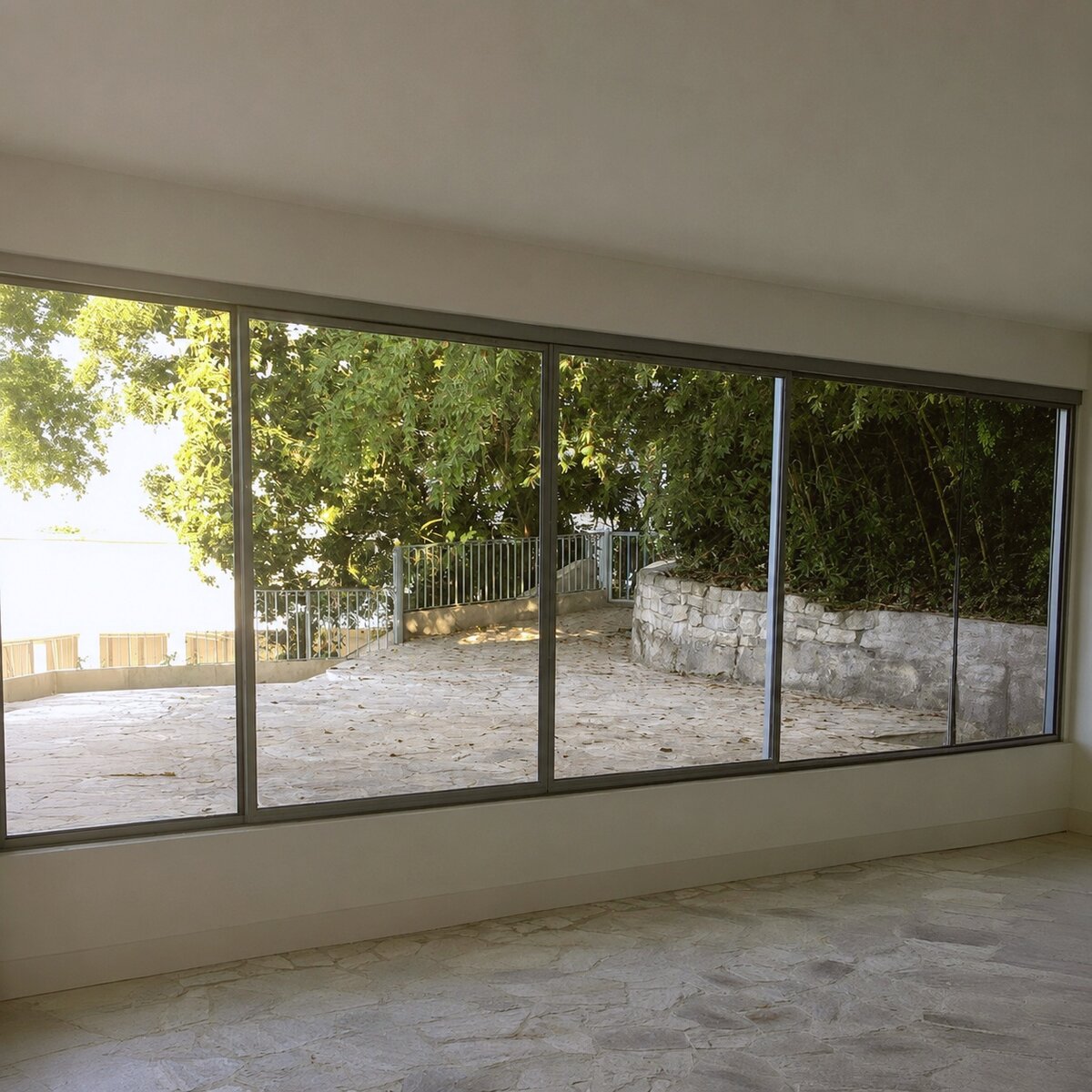 Empty interior room facing the full-height sliding glass doors to the terrace