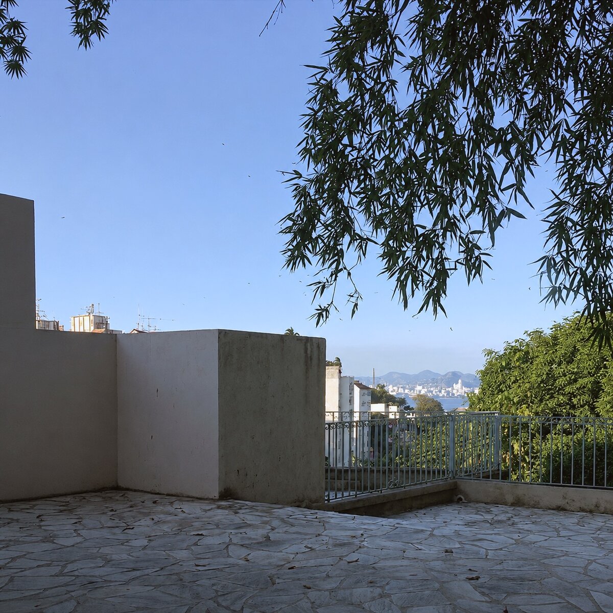 Empty private terrace with stone paving and bay view, no furniture
