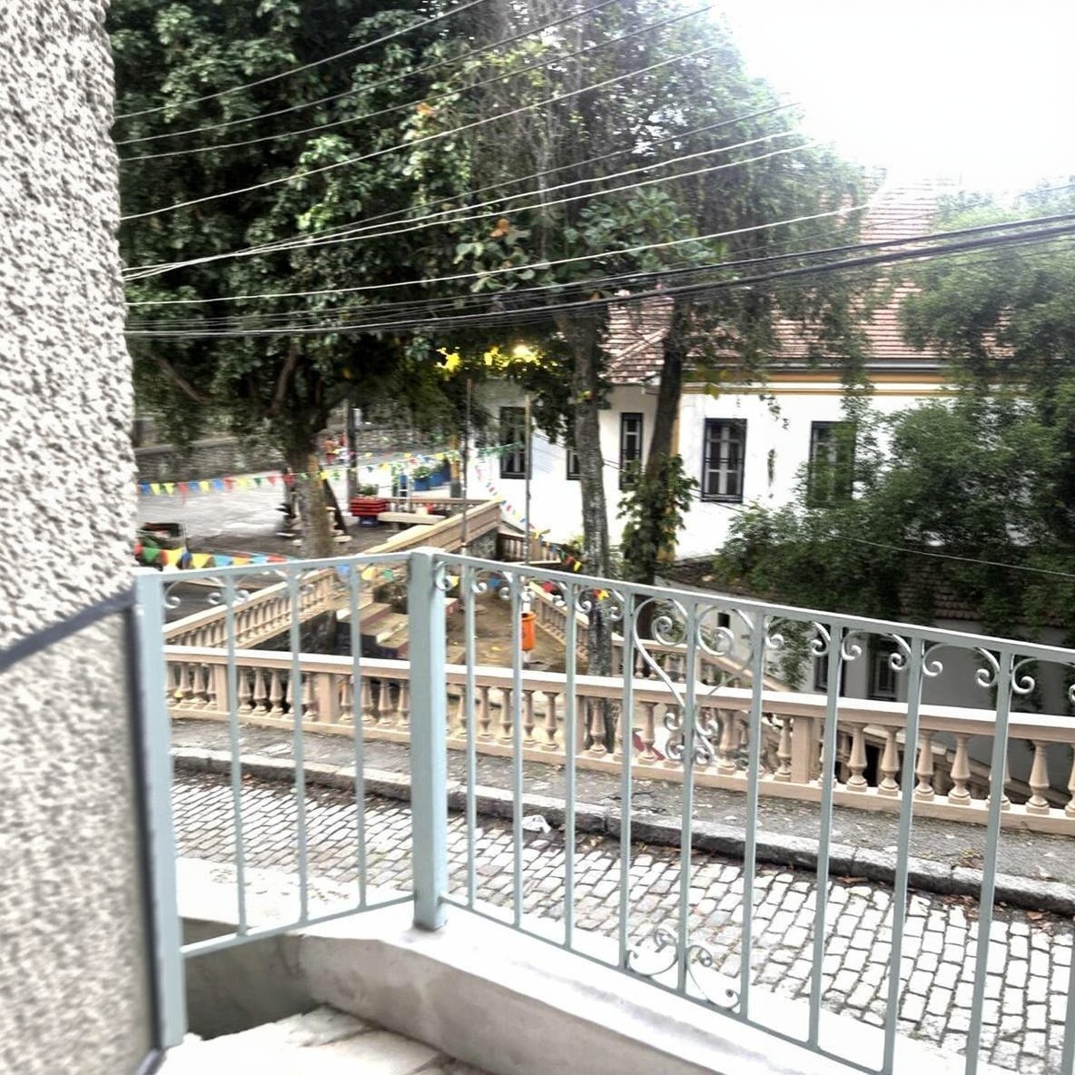 Balcony overlooking a bunting-strung Santa Teresa street corner