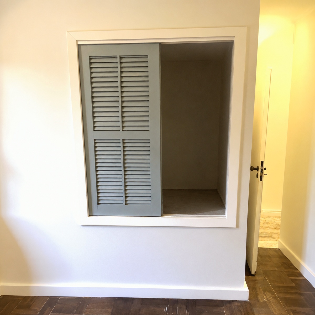 Built-in hallway closet with louvered sliding door