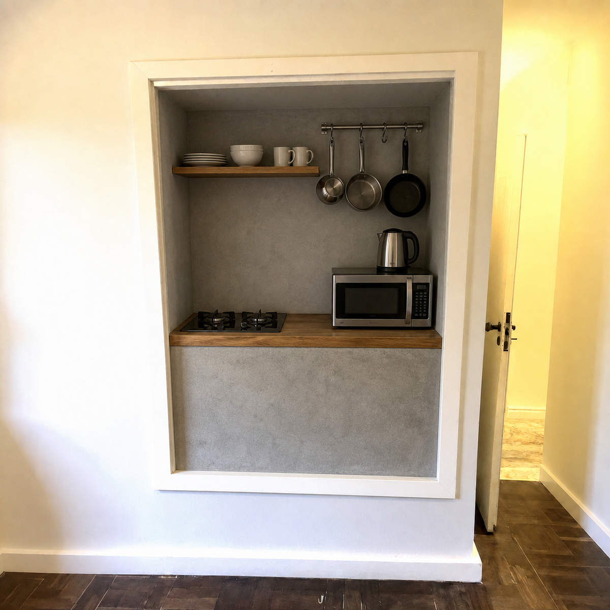 AI visualization of the same closet with its door removed and a compact kitchen shelf, cooktop, microwave, kettle, and hanging pots added