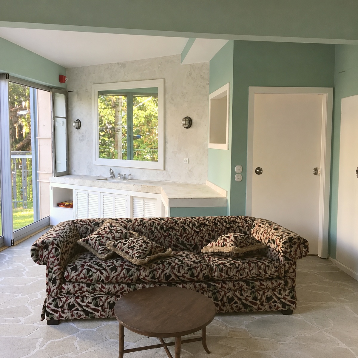Kitchen with marble counter, sink, and the existing sofa and coffee table